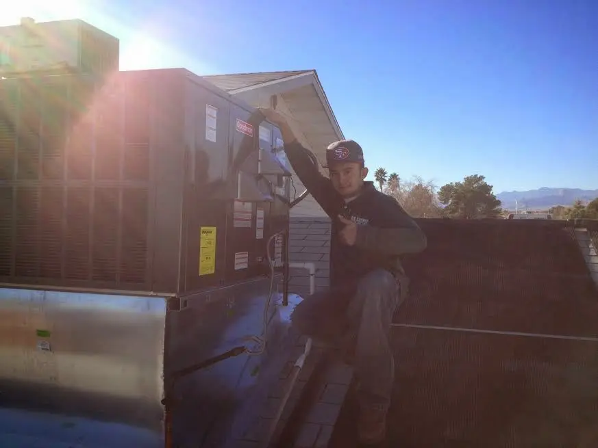 HVAC technician performing Heat Pump Repair on a rooftop unit in Yuba City
